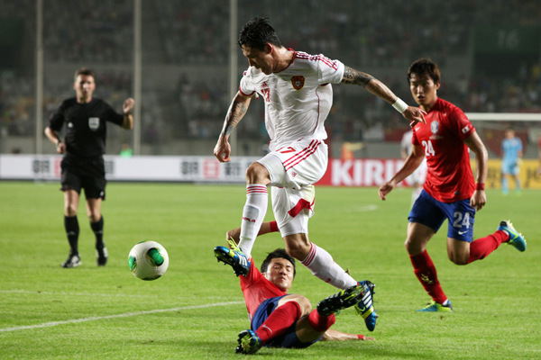 Chinese defender Zhang Linpeng evades a tackle from a South Korean player during an East Asian Cup game on July 24, which ended in a goalless draw. The team��s performance at the cup brought relief to soccer fans after a humiliating defeat to Thailand in June.PARK JIN-HEE / XINHUA