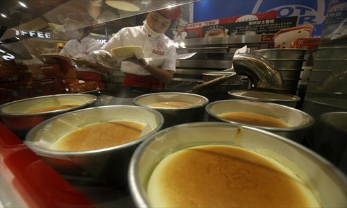 Shop assistants make cakes at the RIKURO bakery in the R��el Department Store on Nanjing Road West Thursday. Photo: Cai Xianmin/GT