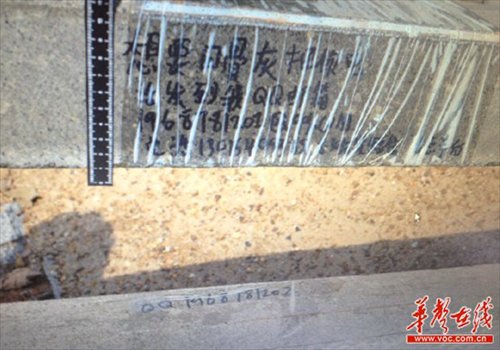 Pictured is a message left on a robbed grave that reads ��send your phone number to my email if you want these ashes back,�� along with contact information. The gravestone was partly wrapped in plastic, perhaps for fears that rain would wash away the message. Photo: voc.com.cn