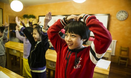 Students at the school contort themselves into different poses as part of an exercise for learning pinyin. Photo: Li Hao/GT