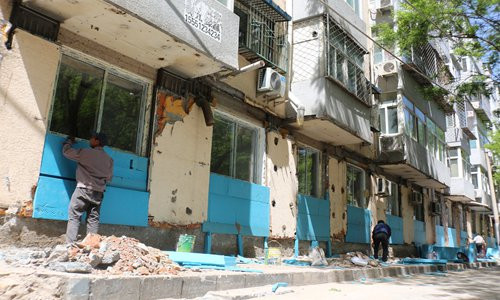 Construction workers erect walls to replace shop facades at the first floor of an apartment building on Tuanjiehu Road, Beijing on Monday, part of a local government crackdown on illegal construction. (Photo: Liu Caiyu/GT)