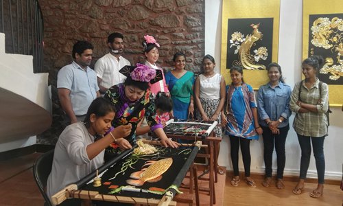 Liu Yamei, a leading cultural heritage inheritor in China, teaches Sri Lanka visitors about Manchu embroidery at an exhibition on Tuesday. (Photo: courtesy of Liu)