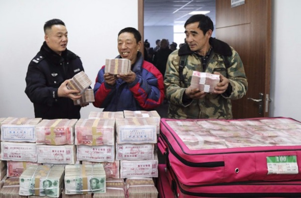 Migrant workers receive wages that police helped them recover from employers who defaulted on payments in Shenyang, Liaoning province, on Tuesday. ��Cai Jingyu/For China Daily��