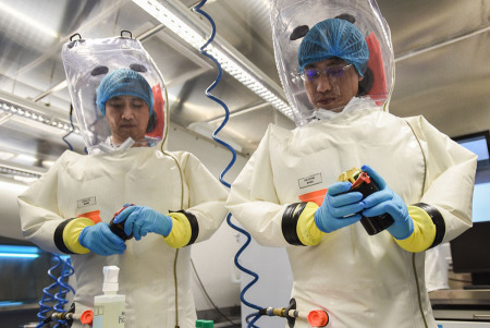 Virologists read data on a container for viral samples at China's first level-four biosafety lab at the Institute of Virology in Wuhan, Hubei province, on Wednesday. (Photo/China Daily)