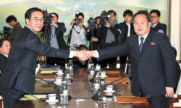 Ri Son-gwon (right), chairman of the Committee for the Peaceful Reunification of the Fatherland of the Democratic People's Republic of Korea, shakes hands with Unification Minister Cho Myoung-gyon of the Republic of Korea in the truce village of Panmunjom on Tuesday. ��Photo/Xinhua��