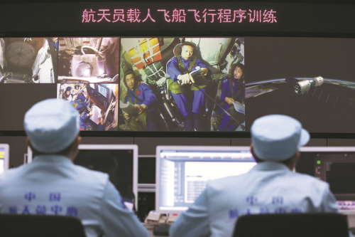 Astronauts Chen Dong (from left), Liu Wang and Liu Yang receive orders from ��mission control�� technicians during a training procedure in Beijing this month. (Photo/CHINA DAILY)