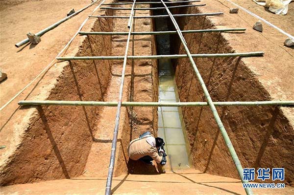 A photographer takes a picture of the archaeological excavation site in Pingyao township, Hangzhou city, Zhejiang province, March 15, 2016. Archeologists have excavated 11 dikes near the ancient city of Liangzhu in the Yuhang district of Hangzhou. (Photo/Xinhua)