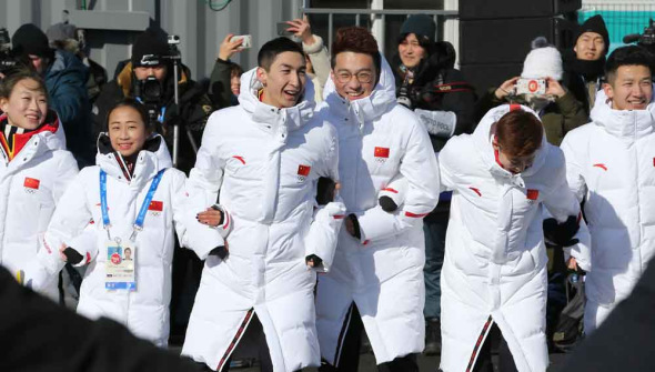 Chinese athletes and coaches dance to Korean pop music following a flag-raising ceremony ahead of the 2018 Winter Olympics in Pyeongchang on Wednesday. ��FENG YONGBIN/CHINA DAILY��