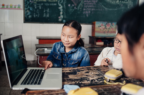 Students at Anding Primary School use a computer to view images after being taught by Liu Yuyang, a freelance photographer. ��Photo by Liu Yuyang/For China Daily��