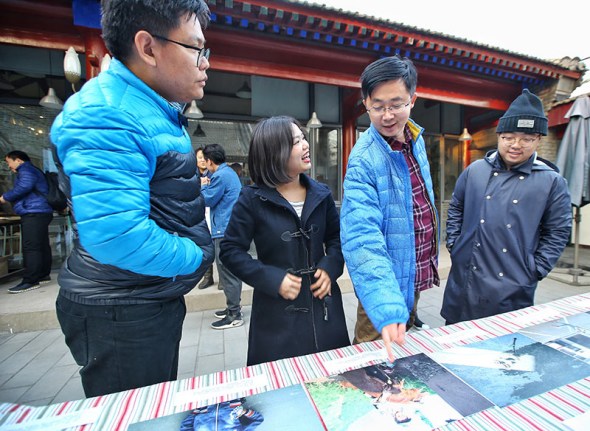 Liu Yuyang (far right) assesses photos by children from rural areas.��Photo by Liu Yuyang/For China Daily��