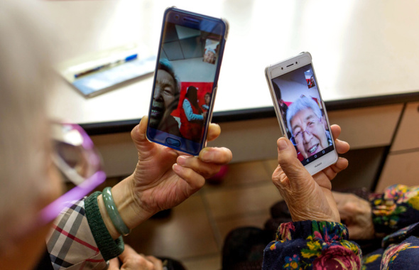 Two elderly women show how they use their smartphones for video chats during an internet class for senior citizens in Taiyuan, Shanxi province. ��Photo/China Daily)