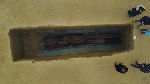 Archeologists gather around a wooden coffin discovered at the M154 site in Sichuan Province. (Photo/Courtesy of Wang Tianyou)
