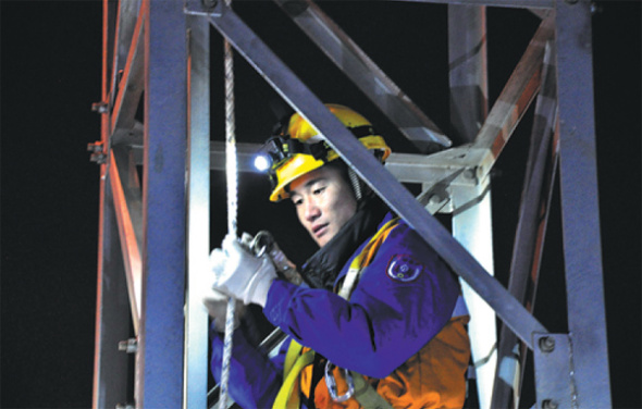 Railway worker Feng Weidong checks a light tower beside tracks in Kunming, Yunnan province. (Photo provided to China Daily)