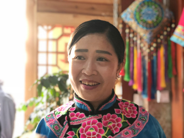 Chen��s wife Zhu Xiuqiong poses at their shop in Yanmen on May 8, 2018. (Photo by Yao Yao/chinadaily.com.cn)
