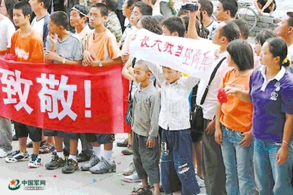 Cheng holds a banner I want to become an airborne trooper when I grow up as airborne troops leave after their rescue work in the 2008 Wenchuan earthquake. (Photo/81.cn)