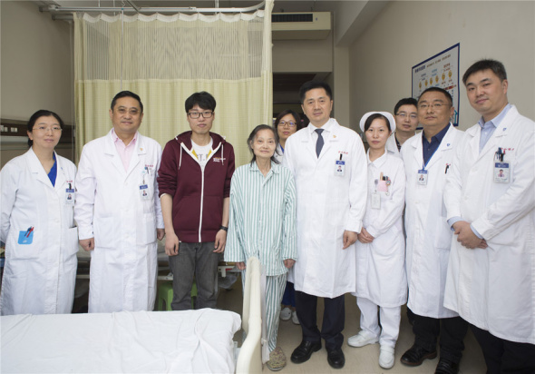 Mr Xie and his mother pose for a picture with medical staff from Zhongshan Hospital on May 10, before they were discharged from the hospital. ��Photo provided to chinadaily.com.cn��