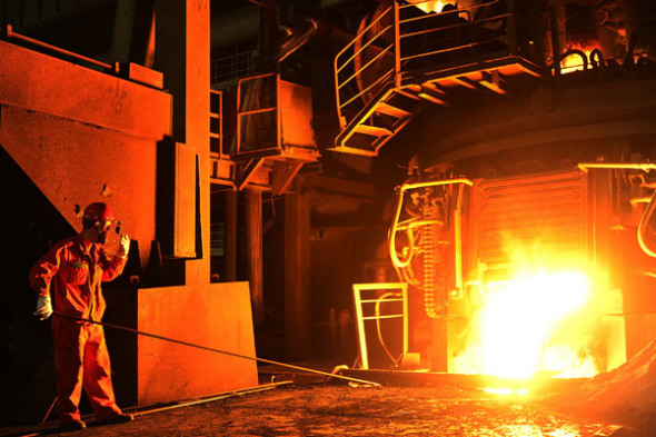 A worker checks molten steel at an iron and steel plant in Dalian, Northeast China's Liaoning province. ��Photo by Liu Debin/For China Daily��