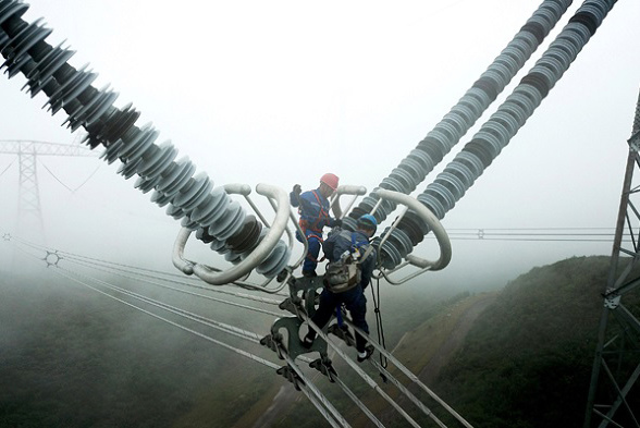 Two technicians from China Southern Power Grid inspect the Guizhou section of the ��800kV Northwestern Yunnan-Guangdong UHV DC power transmission project. (Photo/Xinhua)