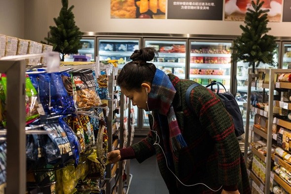 A customer picks British snacks at a supermarket in Beijing. (Photo provided to China Daily)