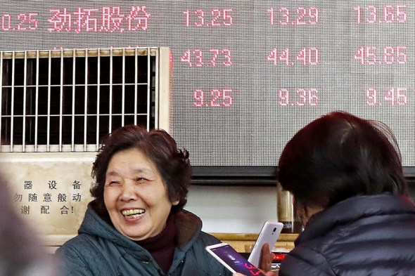 Investors check share prices at a securities brokerage in Shanghai on Thursday.(Photo/China News Service)