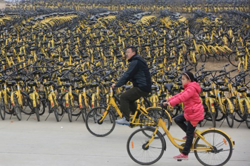 Two customers use Ofo bicycles in Xiangyang, Hubei Province. ��Photo by Yang Dong/For China Daily��