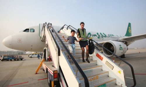A Spring Airlines hostess escorts an unaccompanied child to the airport in Bangkok after a recent flight from Dalian, Liaoning Province. ��Photo provided to China Daily��