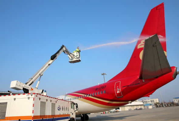 An employee carries out ice prevention operations on an airplane at the Nantong Xingdong International Airport in Jiangsu province. ��Photo by Xu Congjun/For China Daily��