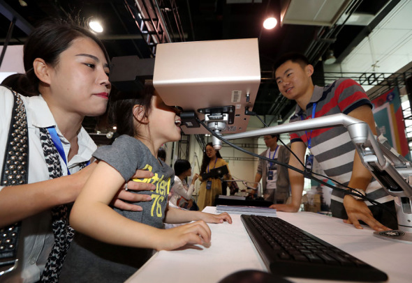 A mom helps her daughter watch a short film on a multi-sensory viewer that can emit aromas, scents and smells related to the content, at the 2018 High-tech Unicorn Enterprise Exhibition held in Hangzhou, Zhejiang province, on April 29. Products like high-tech video viewers distinguish China's unicorns. ��Photo by Lin Yunlong/For China Daily��