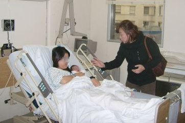 Mrs. Zhou accompanies a client in a hospital. [Photo: <i>Sing Tao Daily (Canada)</i>]