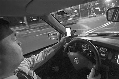 A taxi driver looks for passengers with a taxi-hailing app.[Photo: CFP]