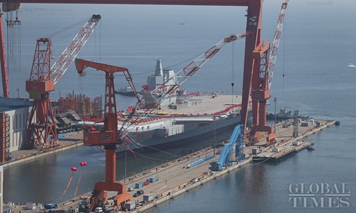 China��s first domestically built aircraft carrier, decorated with red flags and colorful ribbons, prepares to launch from Dalian Port, Northeast China��s Liaoning Province on April 26. (Photo: Cui Meng/GT)