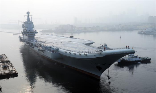 China��s first domestically designed aircraft carrier, which displaces 50,000 metric tons, leaves the Dalian Shipbuilding Industry��s shipyard in Liaoning province on Sunday. (LI GANG/FOR CHINA DAILY)